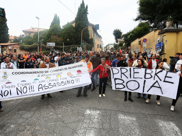 Les gens se rassemblent devant l'église de Lefebvriani pour protester avec une bannière qui dit: "Bourreau Priebke" la semaine dernière à Albano Laziale, Italie.