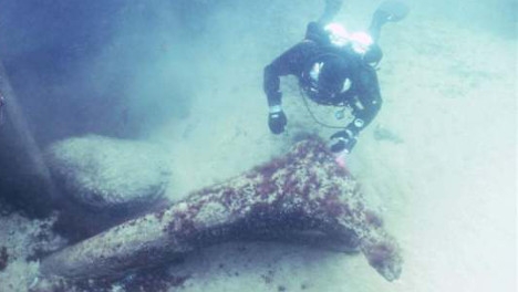 Un plongeur examine un tronc d'arbre  qui a été  estimé à 11,000 ans.Ces  petites découvertes ont permis de dater l'Atlantis suédoise.