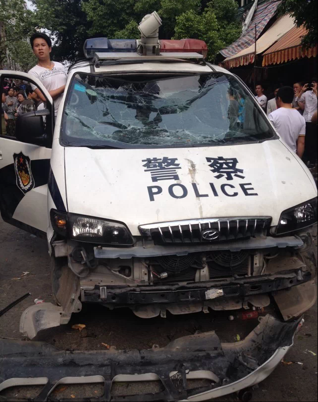 La voiture des policiers a été littéralement prise d’assaut.