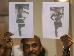 Un officier de police malaisienne détient photos de deux personnes censées être les passagers qui avaient volé des passeports sur la Malaysia Airlines vol a disparu