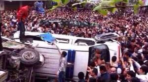 Les fenêtres du van ont été brisées et il a été renversé sur le côté, ..ensuite  la foule a jeté des morceaux de ciment sur les policiers et les a  battu avec des bâtons.