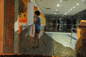 Une femme est vu à travers une vitre cassée à une succursale bancaire (guichet automatique) après une protestation contre la Coupe du Monde de la FIFA, à Rio de Janeiro, près du stade Maracana, le 15 Juin 2014.