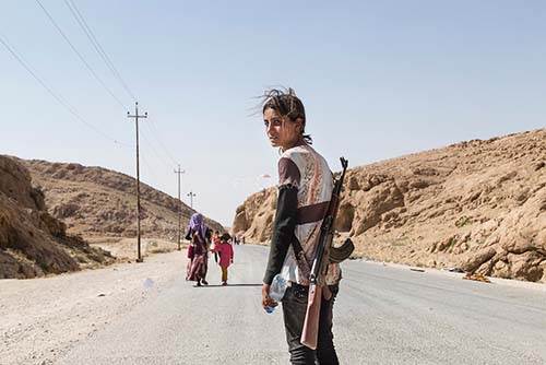 Cette jeune fille yézidie (chrétienne du nord de la Syrie) protège sa famille des attaques terroristes de l'État Islamique,au moyen d'un fusil AK-47.