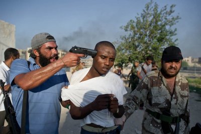 Voici la nouvelle démocratie exportée par les États-Unis en Lybie.Dans quelques secondes après la prise de cette photo,l'homme qui a le pistolet sur la tempe ,mourra...Pour la gloire des terroristes et du 1% qui contrôle les richesses du monde.