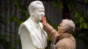 Une vieille militante vient se recueillir devant son buste.