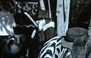 Dans des séquences tournées en coulisse sur le film de Charlie Chaplin Le Cirque, une dame de grande taille, habillée de noir avec un chapeau dissimulant en grande partie son visage, tient à son oreille quelque chose qu’on pourrait confondre avec un téléphone portable. Et son attitude mystérieuse n’évoque en nous qu’une seule chose : exploratrice temporelle.