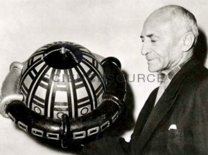 Rudolf Nebel (1894-1978), pionnier de la fusée allemande, tenant une station spatiale modèle en 1955. Il avait élaboré ce projet avant la guerre,mais il était en avance sur son temps.Par contre il attira l'attention du Führer.Neber était un membre du groupe de fusée amateur influent de l'Allemagne, le VfR, dans les années 1930. Il a travaillé aux côtés, entre autres, de Hermann Oberth. Il a rejeté l'utilisation de roquettes dans la guerre, en choisissant de ne pas travailler sous Werner von Braun dans le développement de la fusée nazie V2. Après la Seconde Guerre mondiale, son encouragement et ses conférences publiques ont conduit au recommencement de la recherche allemande sur les fusées. 