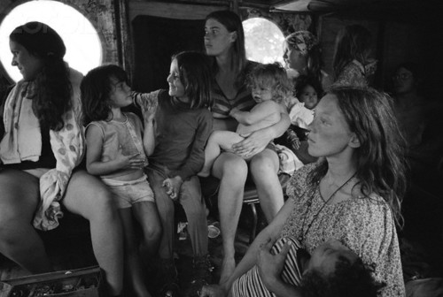 ca. August 15-17, 1969, Near Bethel, New York, USA --- Hog Farm members ride in a bus to the free Woodstock Music and Art Fair. About 450,000 people attended the three day concert, which turned into chaos due to the crowds, heavy rains, and traffic jams. It is nonetheless romantically remembered as a symbol of the liberal spirit of the hippie generation.  The Hog Farm collective ran the free kitchen and the "Freak-Out Tent" for people tripping on hallucinogens. --- Image by © Henry Diltz/CORBIS